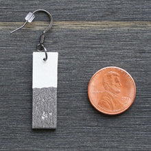 Load image into Gallery viewer, Rectangle dangle earrings made from recycled chipboard, hand painted in white and pewter, and made with gunmetal black ear wire.
