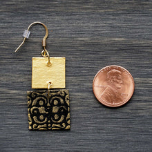 Load image into Gallery viewer, Two-tiered square dangle earrings made from recycled chipboard, hand painted in black and gold, and made with gold ear wire.
